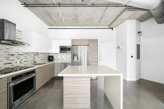 a kitchen with stainless steel appliances a refrigerator and a stove top oven