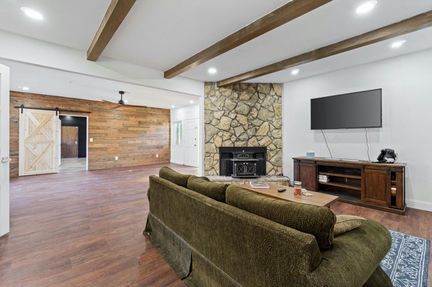 5654 North 7th Street Fresno, CA 93710 - Photo 13 of 38 a living room with furniture a fireplace and a flat screen tv