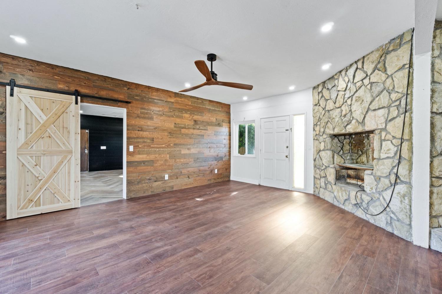 5654 North 7th Street Fresno, CA 93710 - Photo 16 of 38 a view of a livingroom with wooden floor and a ceiling fan