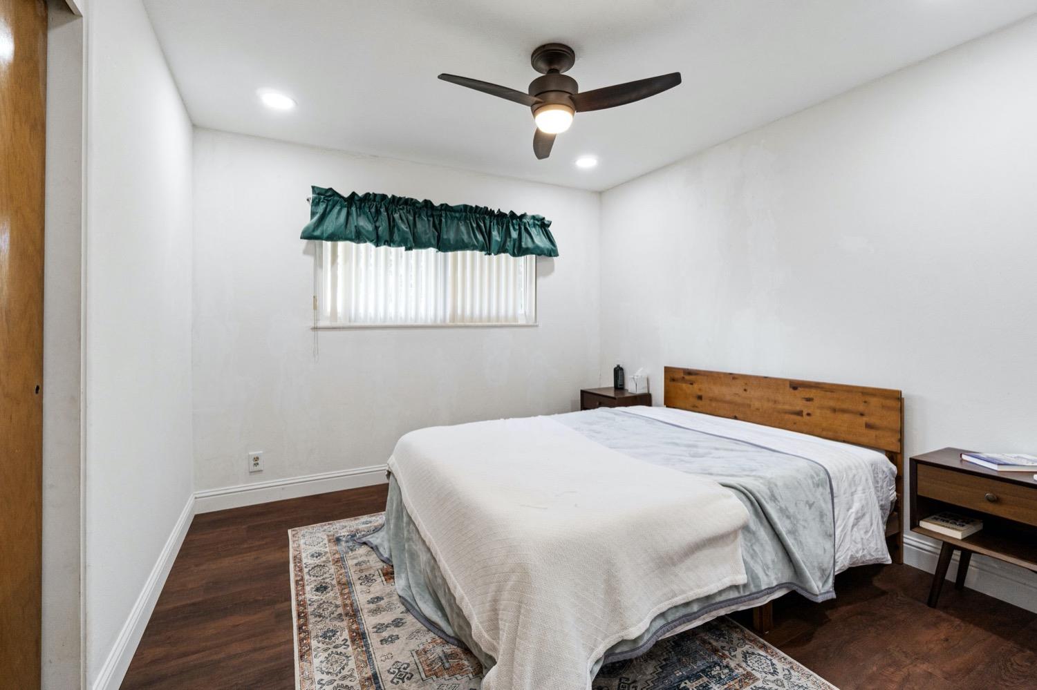 5654 North 7th Street Fresno, CA 93710 - Photo 24 of 38 a bedroom with a bed and a chandelier