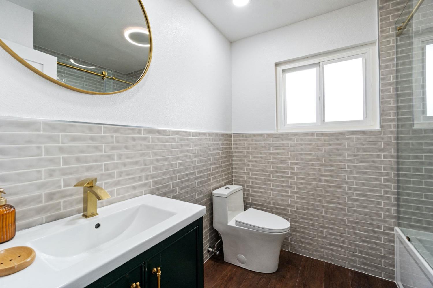 5654 North 7th Street Fresno, CA 93710 - Photo 25 of 38 a bathroom with a toilet a sink and mirror