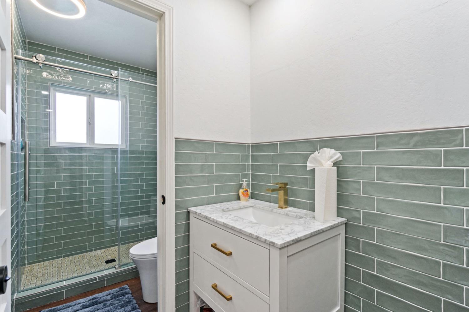 5654 North 7th Street Fresno, CA 93710 - Photo 31 of 38 a bathroom with a sink a toilet and shower