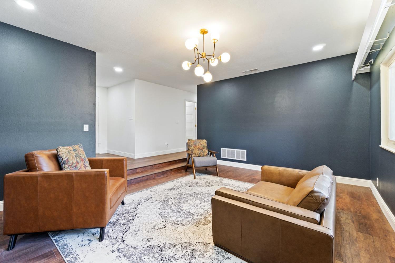 5654 North 7th Street Fresno, CA 93710 - Photo 8 of 38 a living room with furniture and a chandelier