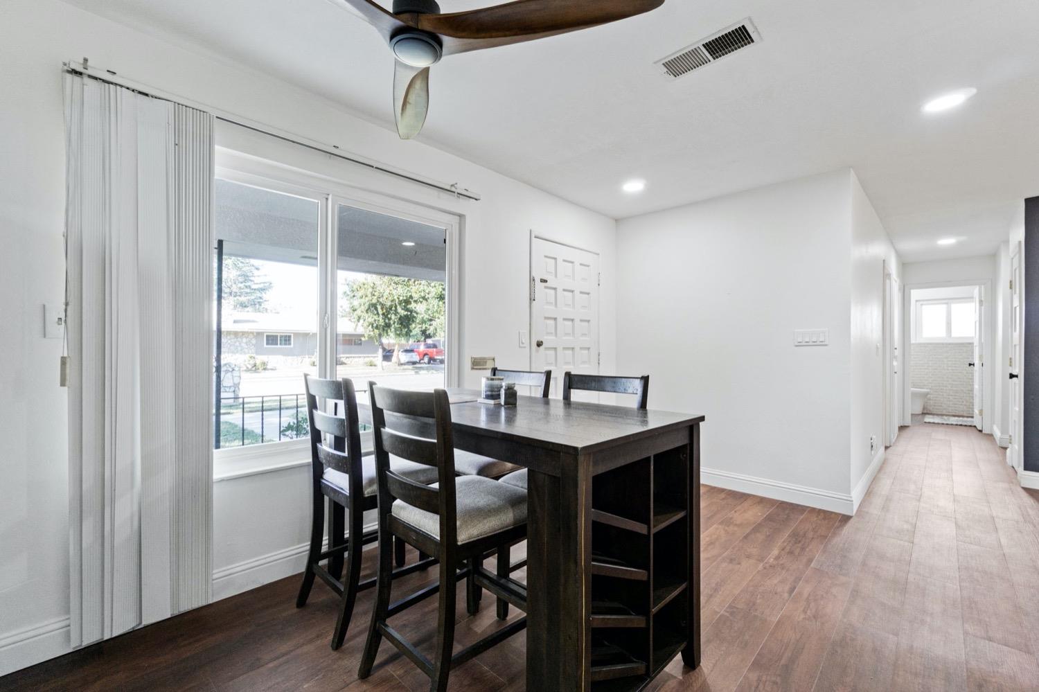 5654 North 7th Street Fresno, CA 93710 - Photo 9 of 38 a view of a dining room with furniture window and wooden floor