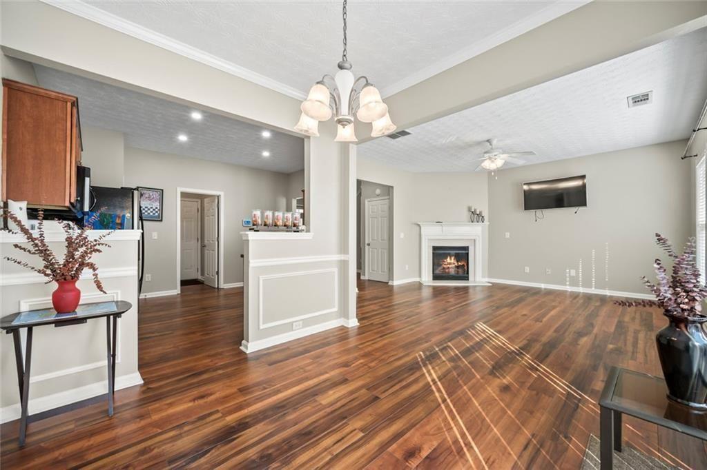 6066 Allpoint Way Fairburn, GA 30213 - Photo 12 of 43 a view of a livingroom with furniture a ceiling fan and wooden floor