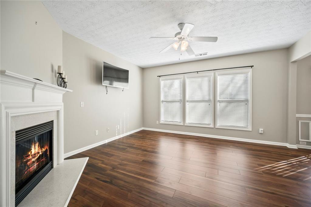 6066 Allpoint Way Fairburn, GA 30213 - Photo 13 of 43 a view of an empty room with wooden floor fireplace and a window
