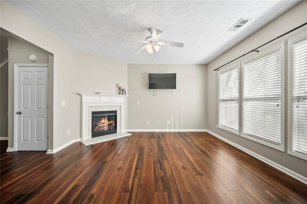 6066 Allpoint Way Fairburn, GA 30213 - Photo 14 of 43 a view of an empty room with wooden floor fireplace and a window