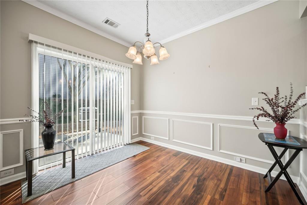 6066 Allpoint Way Fairburn, GA 30213 - Photo 15 of 43 a view of a livingroom with wooden floor and a chandelier