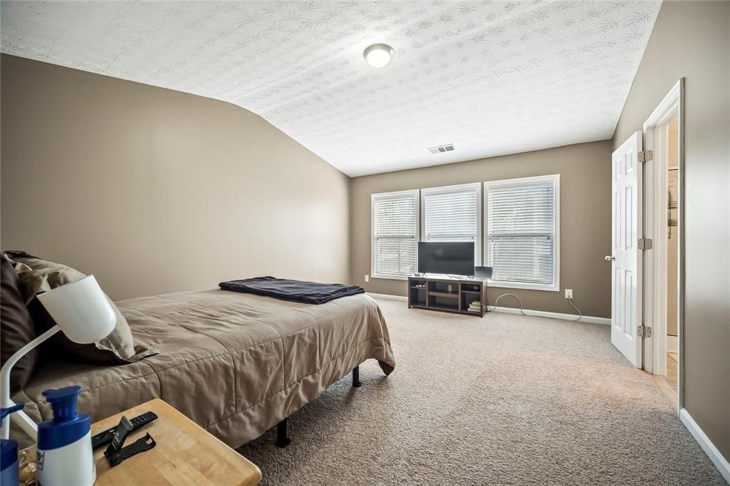 6066 Allpoint Way Fairburn, GA 30213 - Photo 19 of 43 a bedroom with a bed and a large window with couch