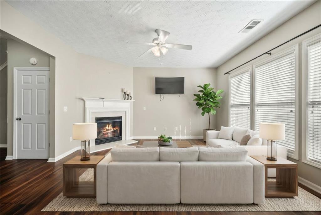 6066 Allpoint Way Fairburn, GA 30213 - Photo 2 of 43 a living room with furniture a fireplace and a flat screen tv