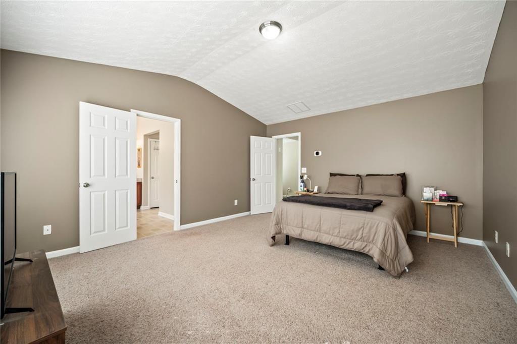6066 Allpoint Way Fairburn, GA 30213 - Photo 21 of 43 a spacious bedroom with a bed and a cabinets