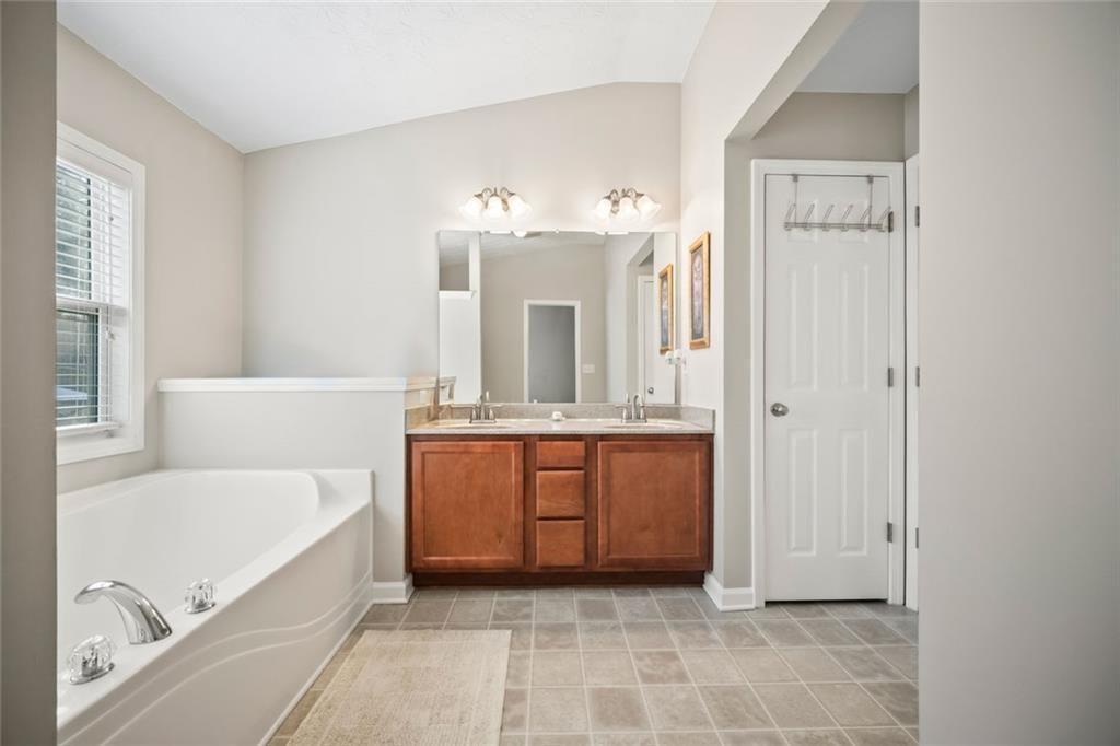 6066 Allpoint Way Fairburn, GA 30213 - Photo 22 of 43 a bathroom with a tub sink and mirror