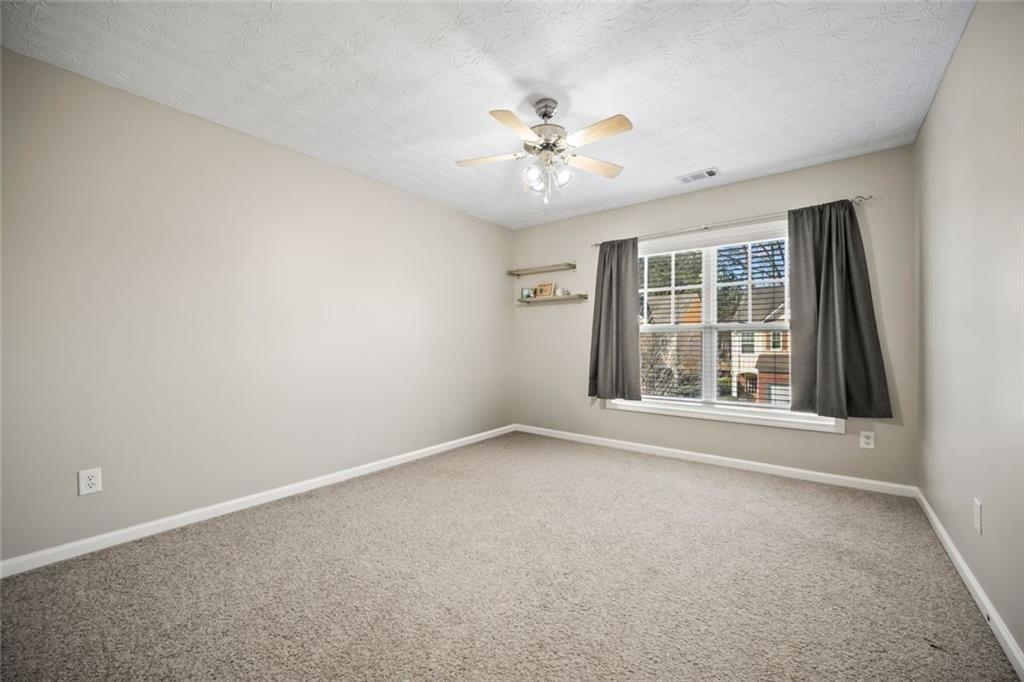 6066 Allpoint Way Fairburn, GA 30213 - Photo 27 of 43 an empty room with chandelier fan and windows