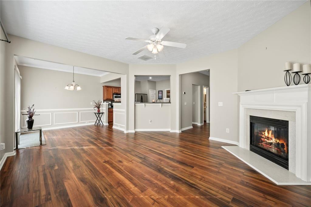 6066 Allpoint Way Fairburn, GA 30213 - Photo 4 of 43 a view of a livingroom with wooden floor and a fireplace