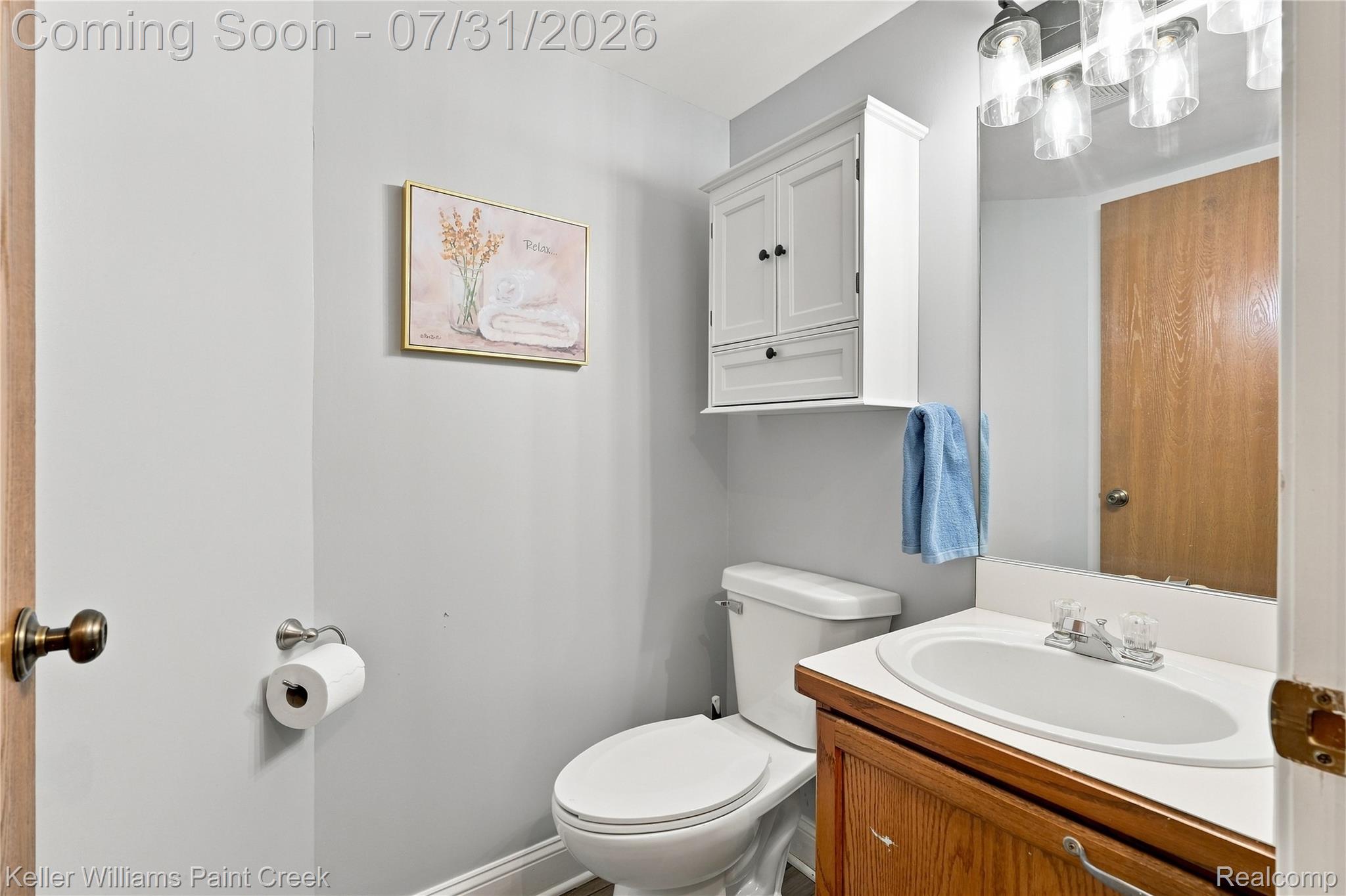 3009 High Pointe Ridge Road Lake Orion, MI 48359 - Photo 11 of 21 Bathroom featuring a wood-finish vanity with an integrated sink, a wall-mounted medicine cabinet, and a multi-bulb light fixture