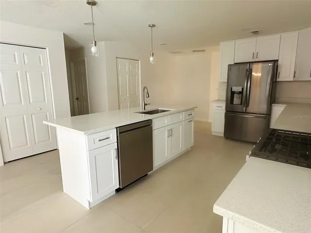 a kitchen with white cabinets and stainless steel appliances