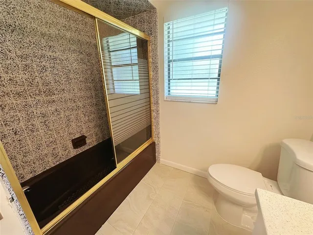 a bathroom with a toilet and a shower
