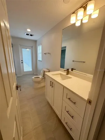 a spacious bathroom with a double vanity sink a toilet and a mirror