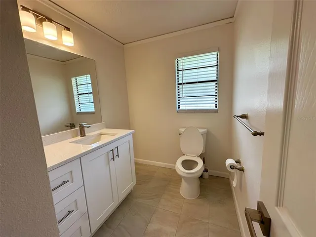 a bathroom with a granite countertop toilet a sink and a mirror