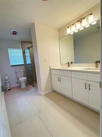 a view of a double vanity sink mirror and cabinets