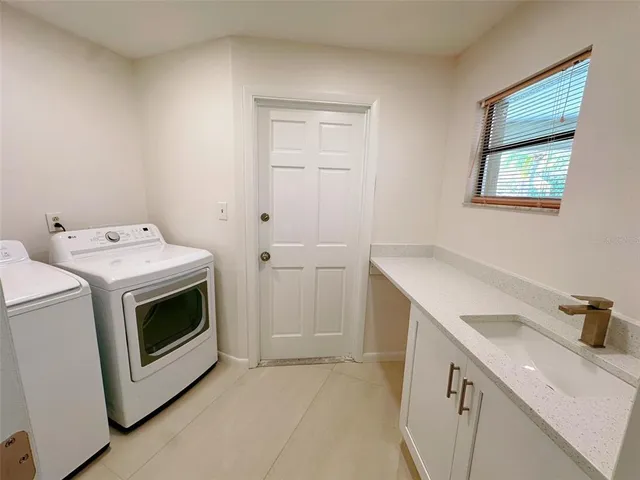 a utility room with sink dryer and washer