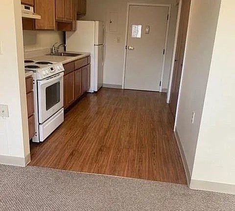 1109 East North Street, Unit 20 Victoria, TX 77901 - Photo 9 of 9 a kitchen with wooden floors and white appliances