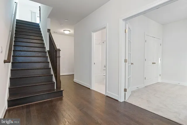 a view of a hallway with wooden floor and entryway