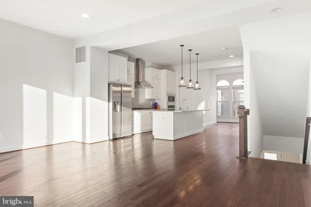 a view of a kitchen with wooden floor and electronic appliances