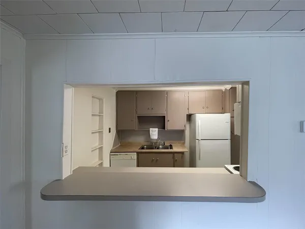 a kitchen with cabinets and refrigerator