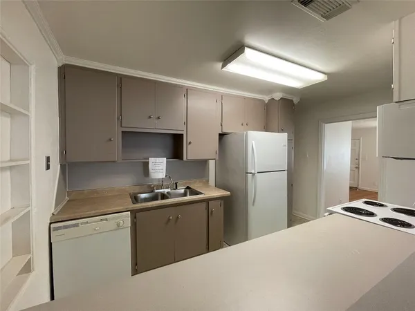 a kitchen with a refrigerator sink and cabinets