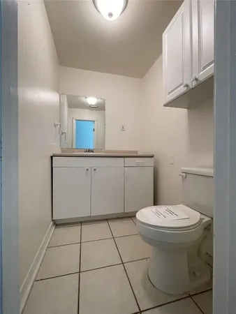 a bathroom with a toilet a sink and mirror