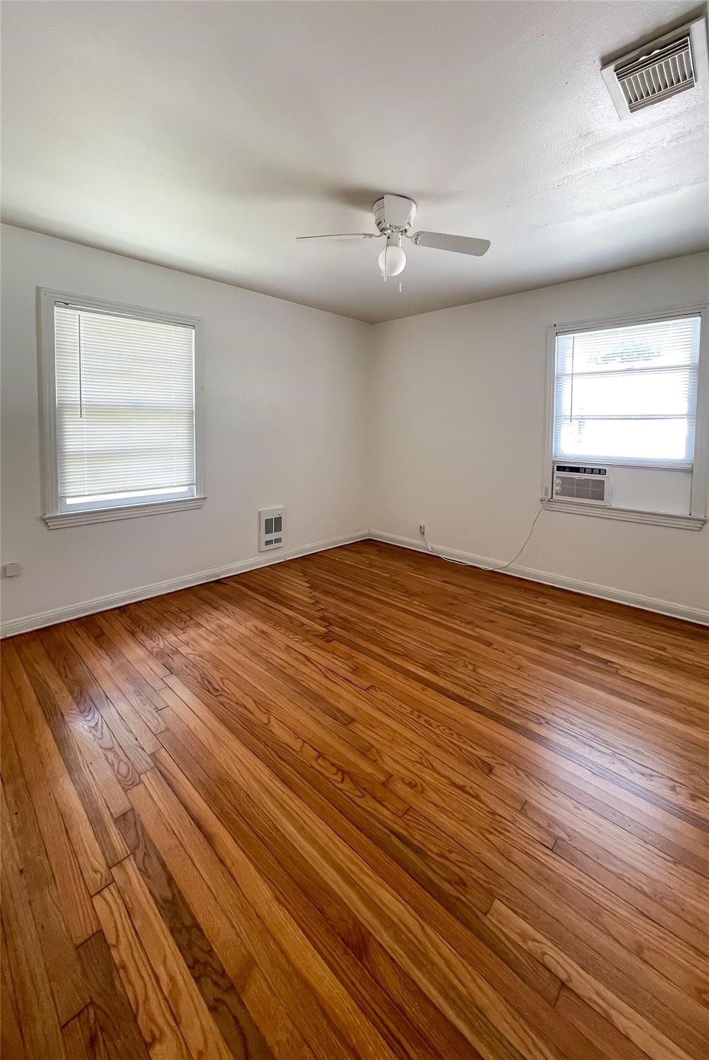 1241 Chevy Chase Drive Angleton, TX 77515 - Photo 3 of 21 an empty room with wooden floor and windows