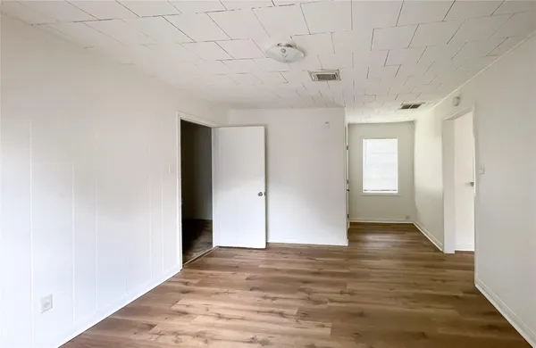 a view of an empty room with wooden floor