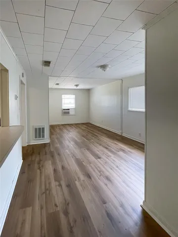 a view of empty room with wooden floor