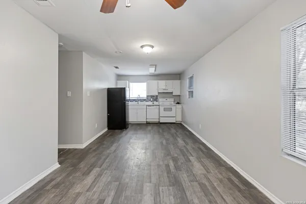a view of a kitchen with wooden floor and an empty space