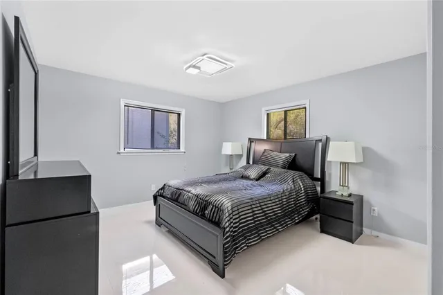 a spacious bedroom with a bed and a refrigerator