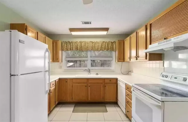 a kitchen with a sink a refrigerator and cabinets