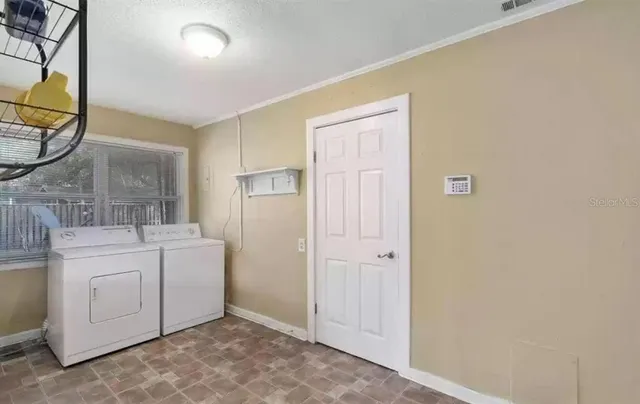 a room with a washer and dryer next to a window