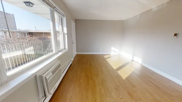 a view of a room with wooden floor and a window