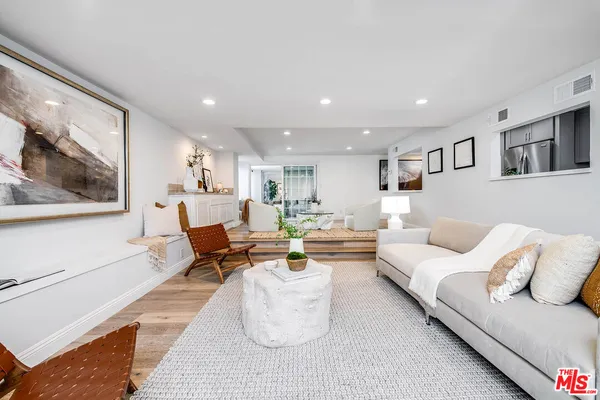 a living room with furniture and painting on the wall