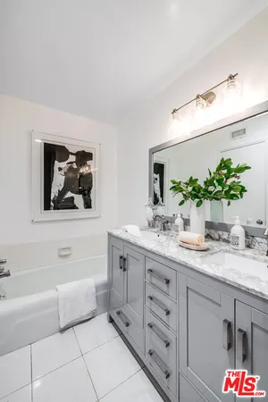 a bathroom with a granite countertop sink mirror and bathtub