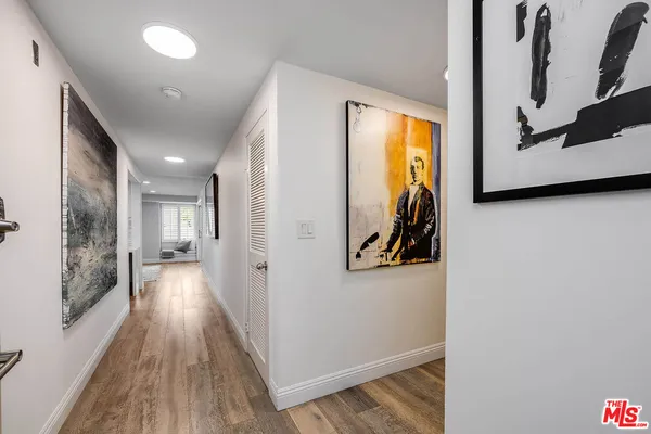 a view of a hallway with wooden floor and closet