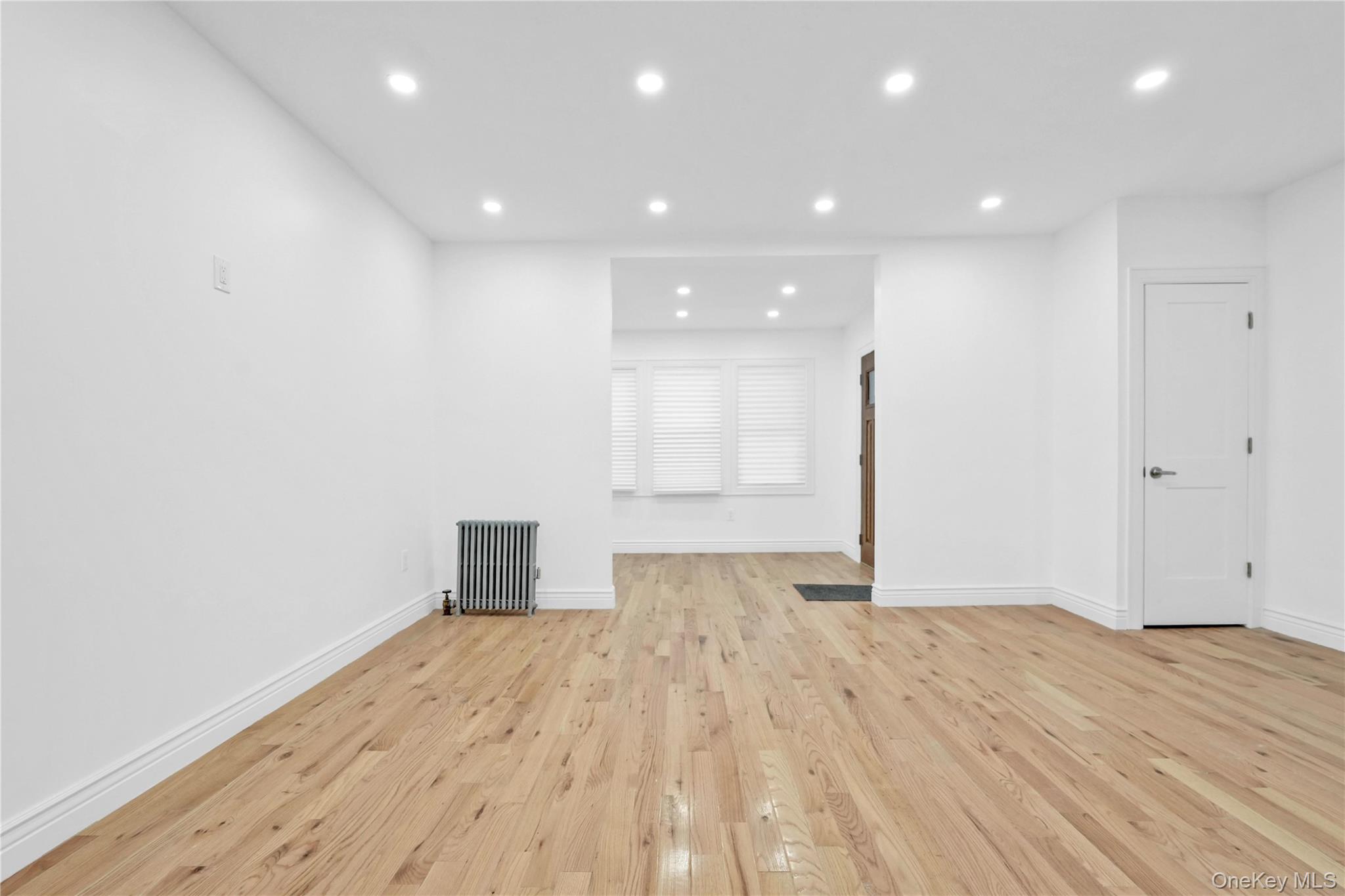 21432 112th Road Queens, NY 11429 - Photo 4 of 18 Unfurnished living room featuring recessed lighting, light wood-style flooring, and radiator