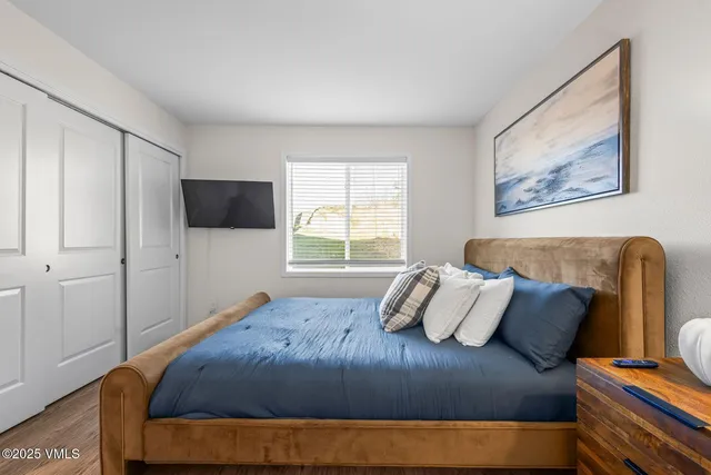 a bedroom with a bed and wooden floor