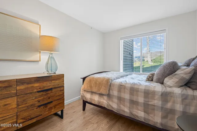 a bedroom with a bed lamp and a window