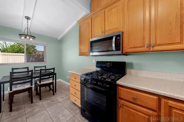 a kitchen with stainless steel appliances a stove a microwave cabinets and a wooden floor