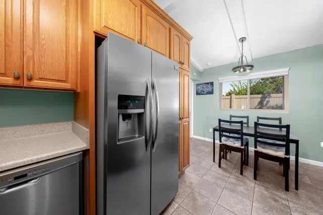 a kitchen with stainless steel appliances a refrigerator a table and chairs