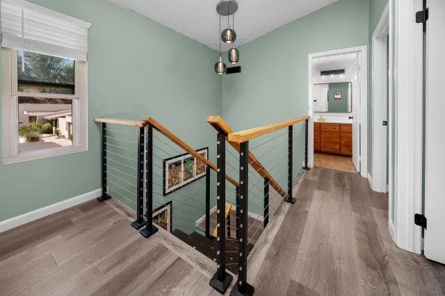 a view of a hallway with wooden floor and staircase