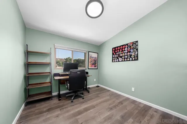 a view of a workspace with furniture and a window