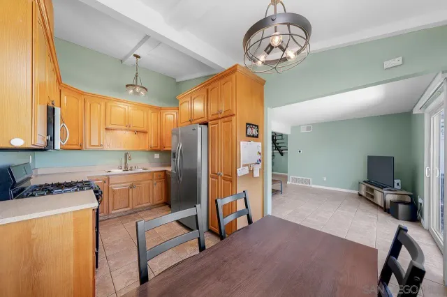 a kitchen with stainless steel appliances granite countertop a refrigerator a stove and a wooden floors